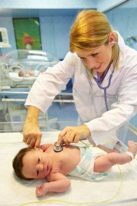 Pediatra explorando a bebe recién nacido